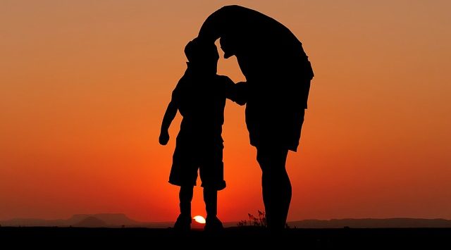vader en zoon bij zonsondergang symbool voor vader na de scheiding
