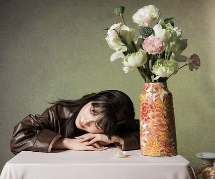 Vrouw hoofd op tafel met bos bloemen. Twijfel om te scheiden of niet